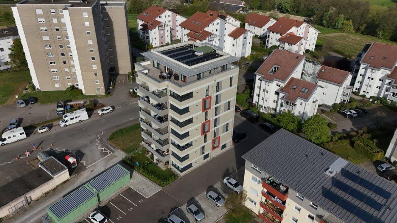 Weitwinkelaufnahme eines Wohnviertels in Tettnang mit unterschiedlichen Mehrfamilienhäusern, einem Hochhaus mit Solaranlage und angrenzenden Feldern.